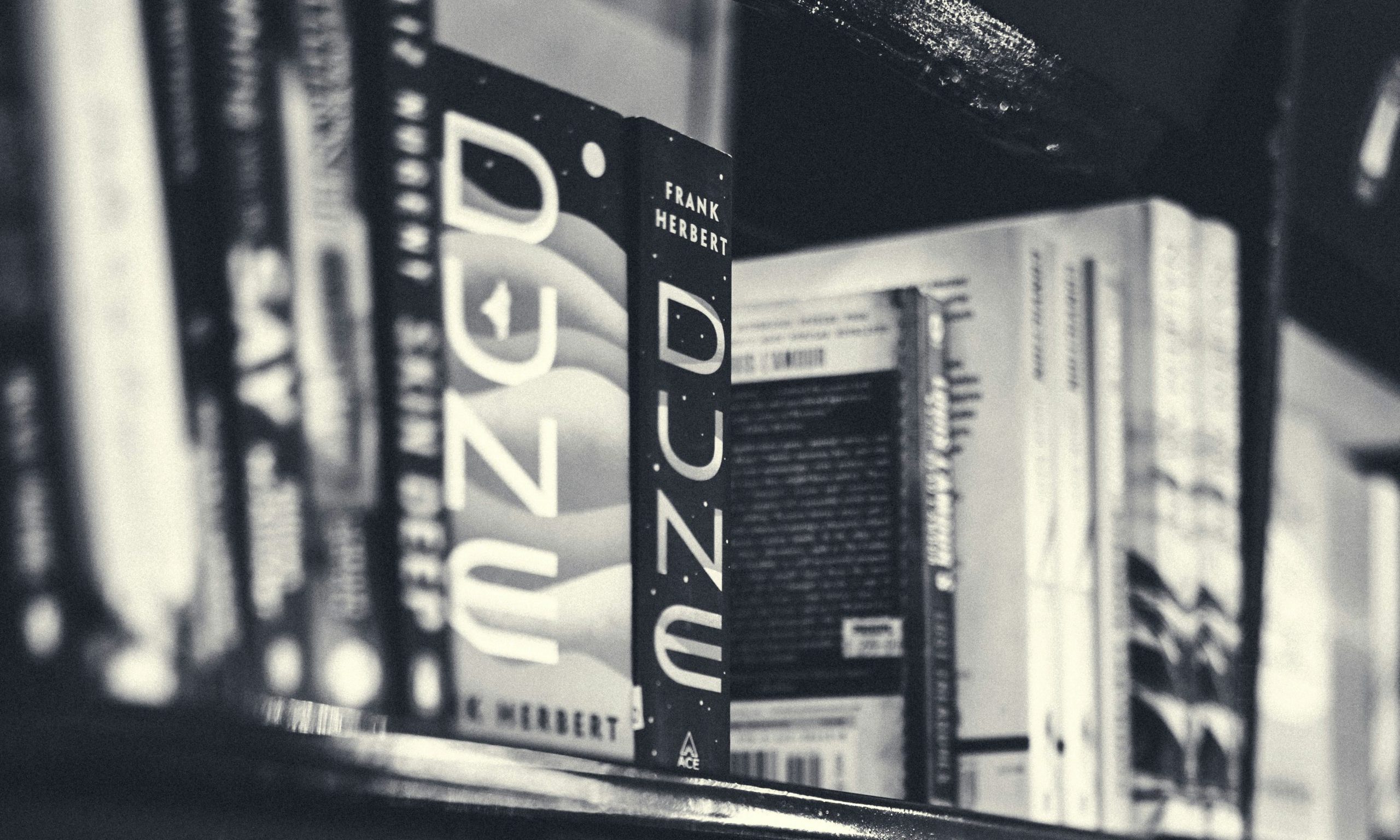 bookshelf with dune books by frank herbert black and white