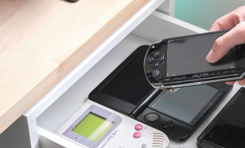 andrew-m-QstVhKiQndg-unsplash playstation portable psp being placed in drawer with gameboy