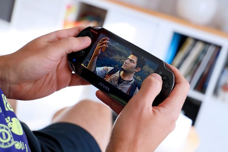 matoo-studio-63Cdx8m7Z9Y-unsplash man holding playstation vita sony ps vita handheld gaming console